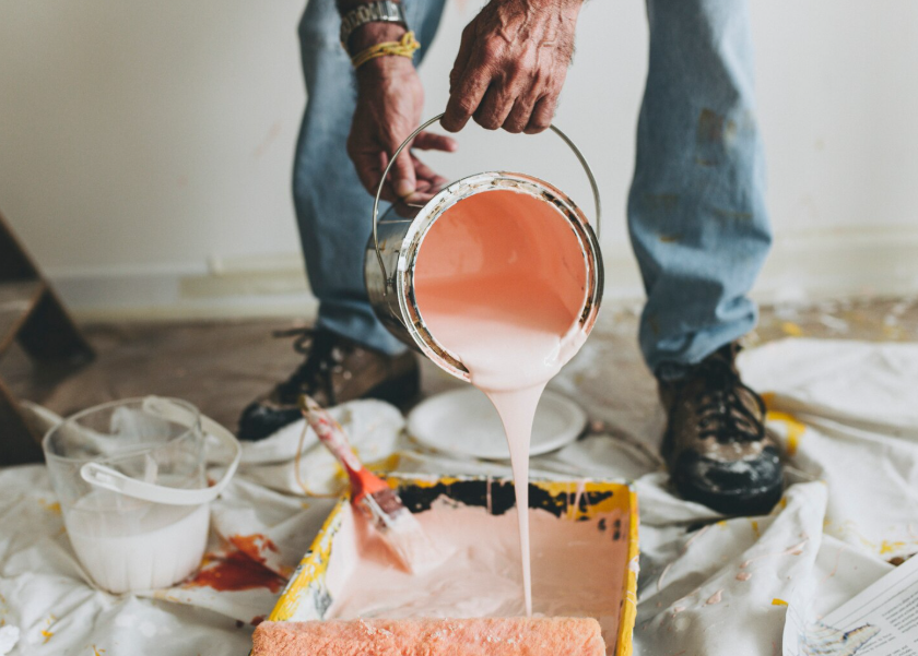 An industrial wide-format printer is captured in the process of outputting a high-quality, full-color architectural or technical document onto a continuous roll of paper.