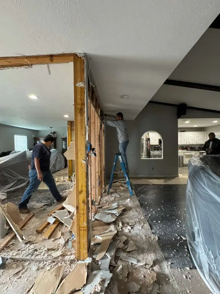 home construction showing removed walls and two people working.