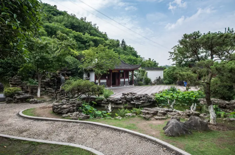 A collection of beautifully manicured gardens features elegant pathways, stone structures, and artistic water elements that seamlessly come together to showcase professional landscape design.