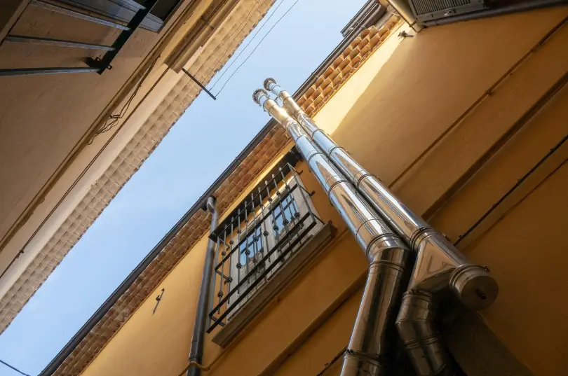 A professional technician uses specialized vacuum equipment and brushes to ensure a thorough chimney cleaning from inside the home's fireplace.
