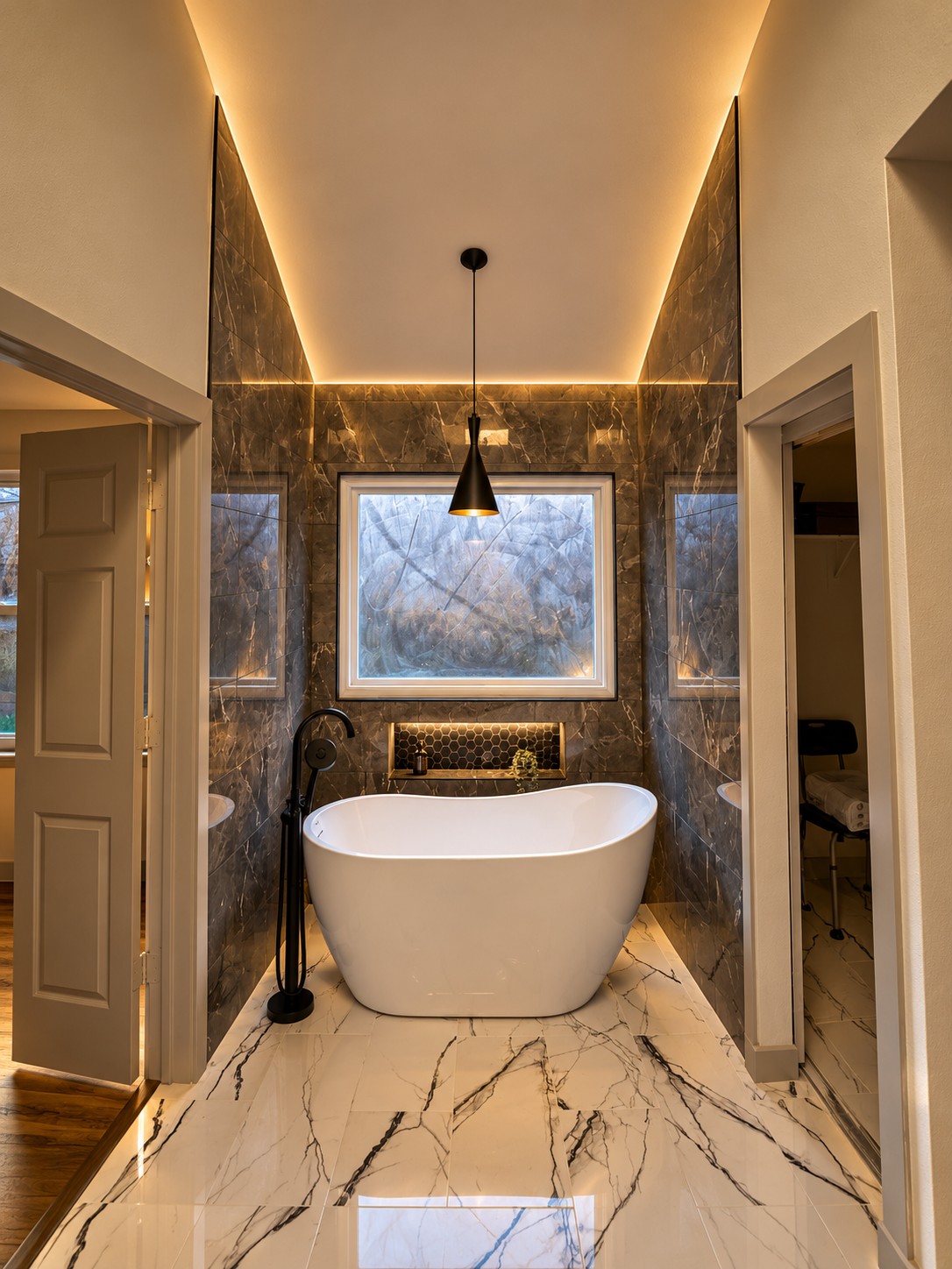 Freestanding tub in a marble alcove with black fixtures by Akraba Construction LLC