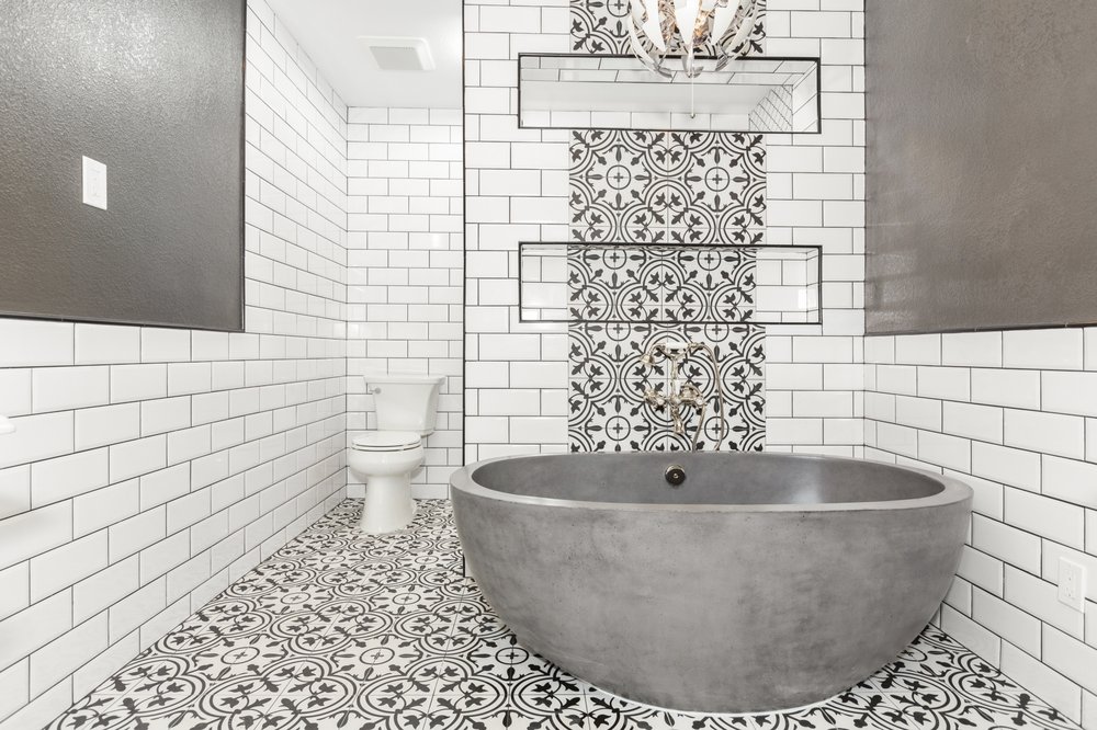 Small bathroom remodel with freestanding concrete tub, subway tile and patterned floor
