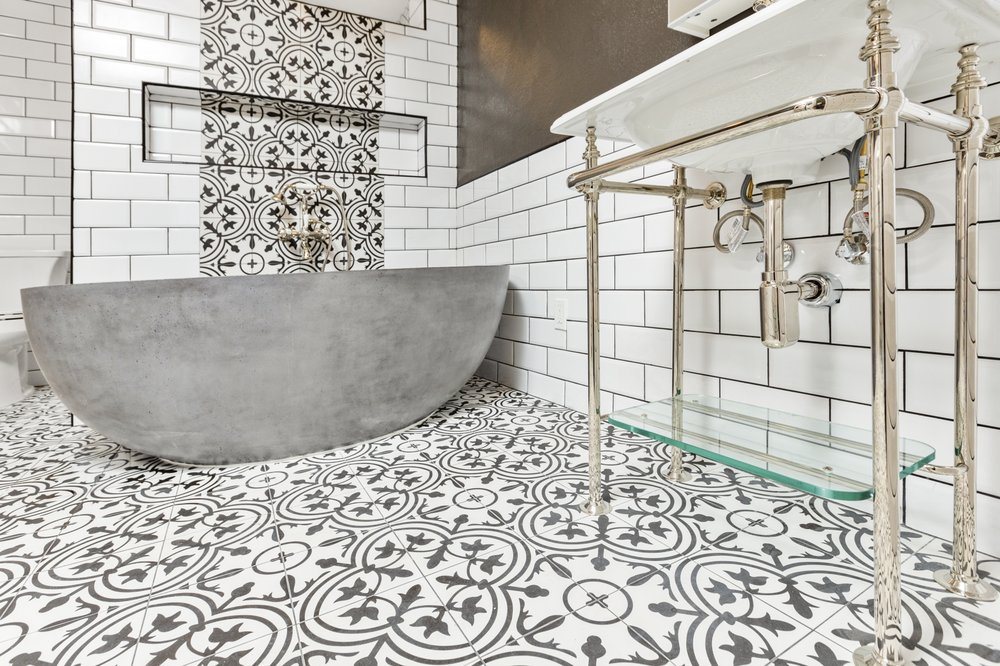 Bathroom remodel with a freestanding stone look tub and patterned tile by Akraba Construction LLC, serving Richardson, TX
