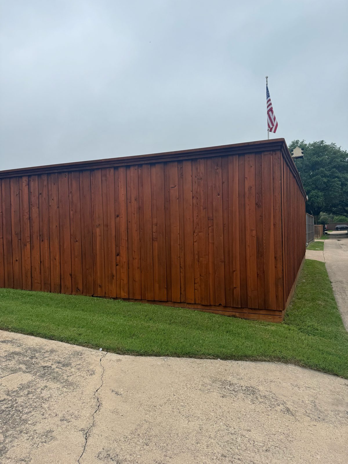 New stained cedar fence with top cap after replacement