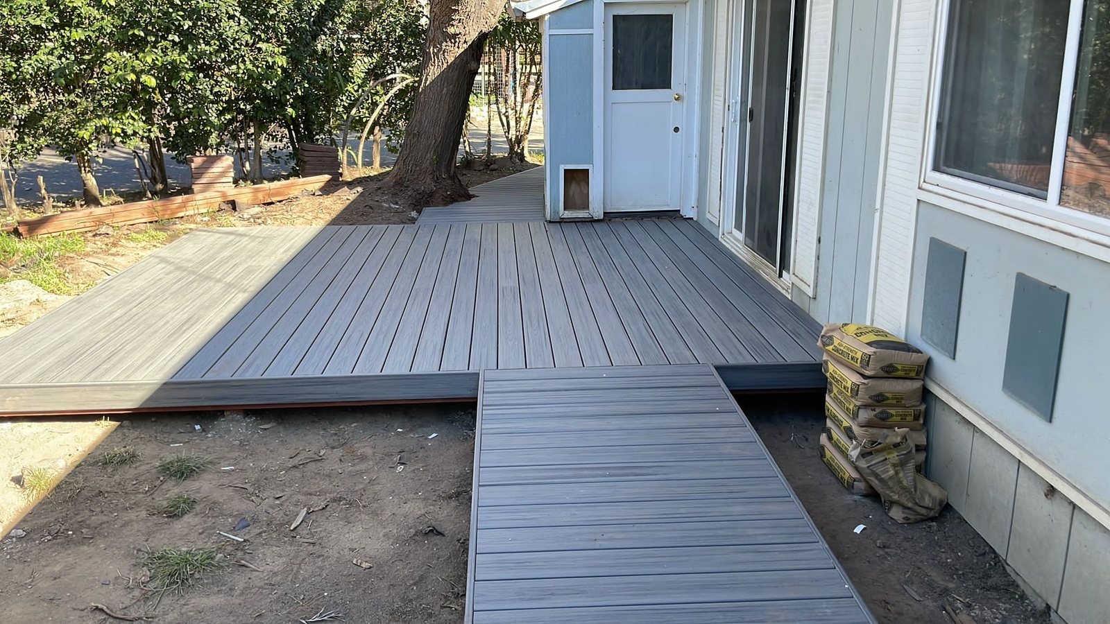 Gray composite deck with a matching walkway built by Akraba Remodeling