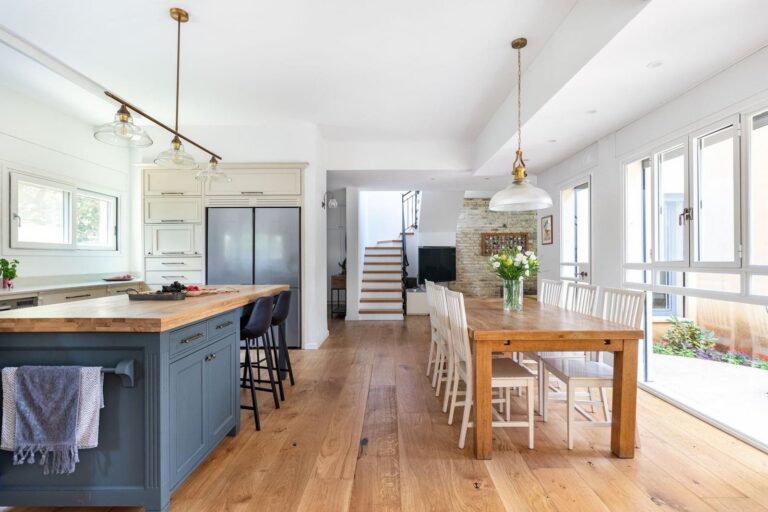 Open-concept kitchen with blue island and wood floors by Akraba, Plano & DFW kitchen remodeler