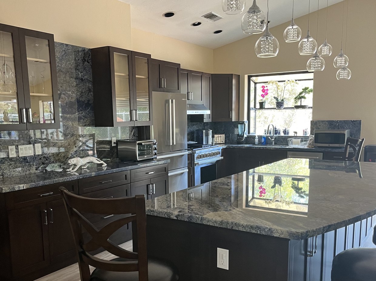 Kitchen remodel with a granite island and crystal pendant lights by Akraba Construction LLC, serving Plano, TX