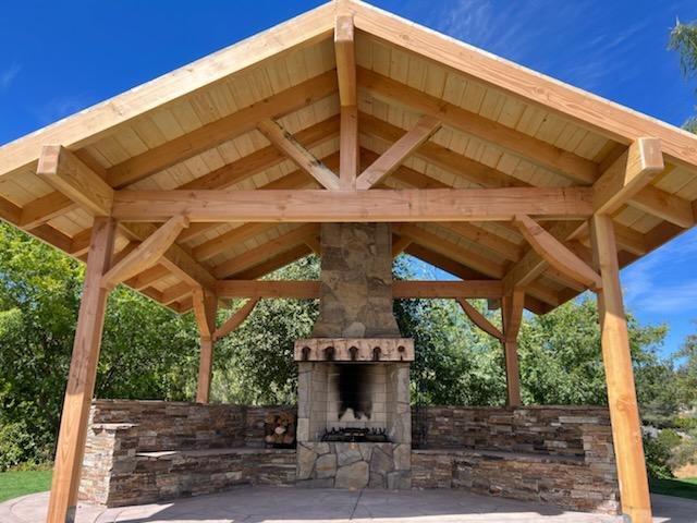 Wood patio cover over a stone outdoor fireplace built by Akraba Remodeling